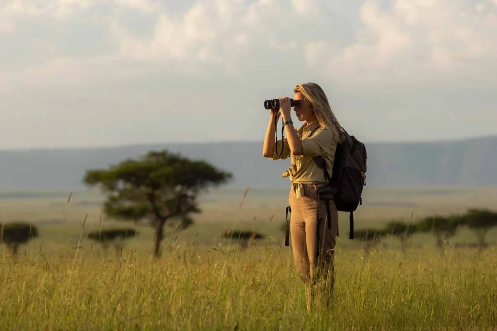 A traveller looking out over the savannah through binoculars