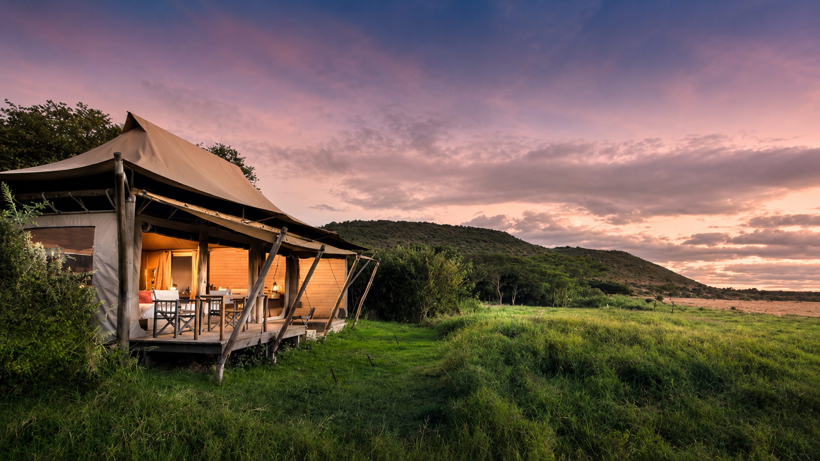 Luxury tented camp overlooking the Masai Mara landscape at sunset